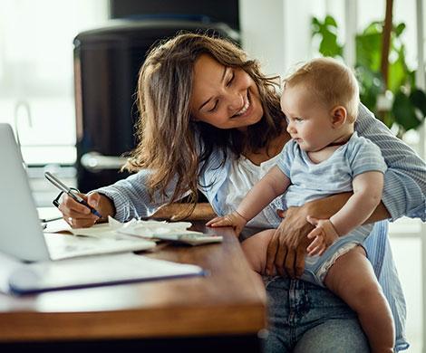 Mother and child sitting at desk in home office