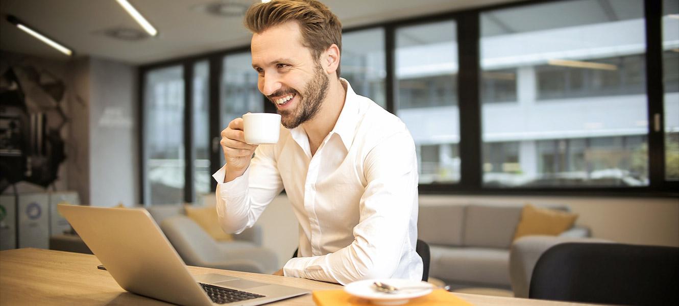 Man having coffee while meet virtually with colleagues